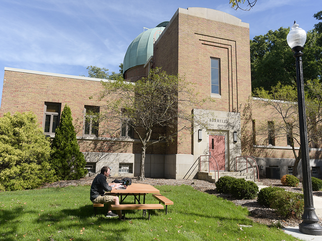 Burrell Observatory outside view with man sitting at lunch table 
